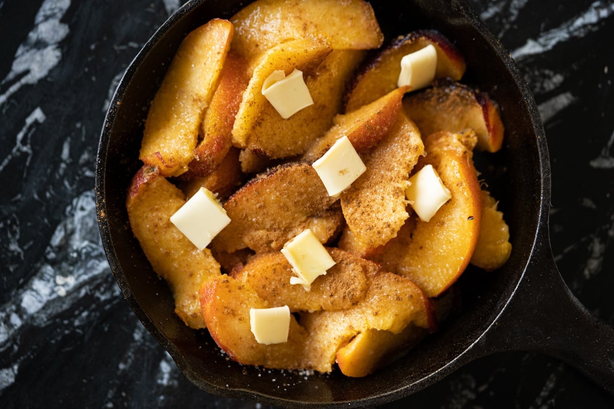 The peach cobbler filling with butter dots and cinnamon