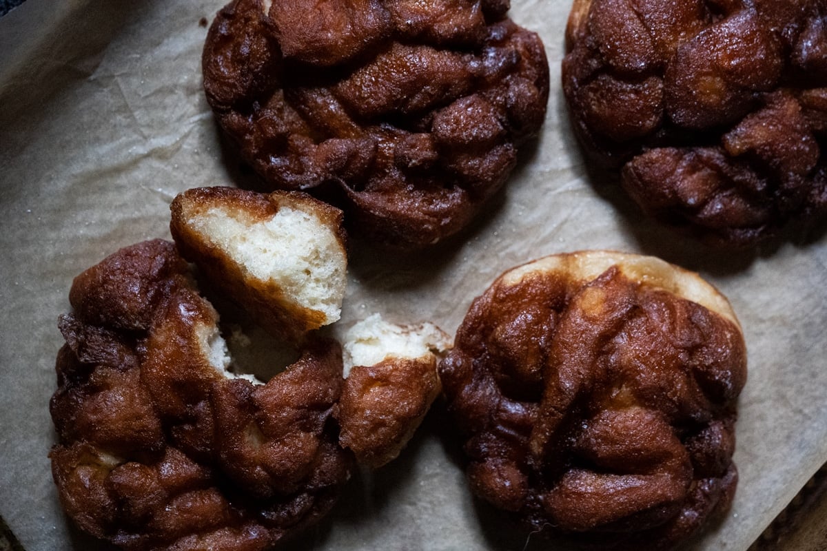 A baked keto apple fritter torn in half to show the fluffy texture