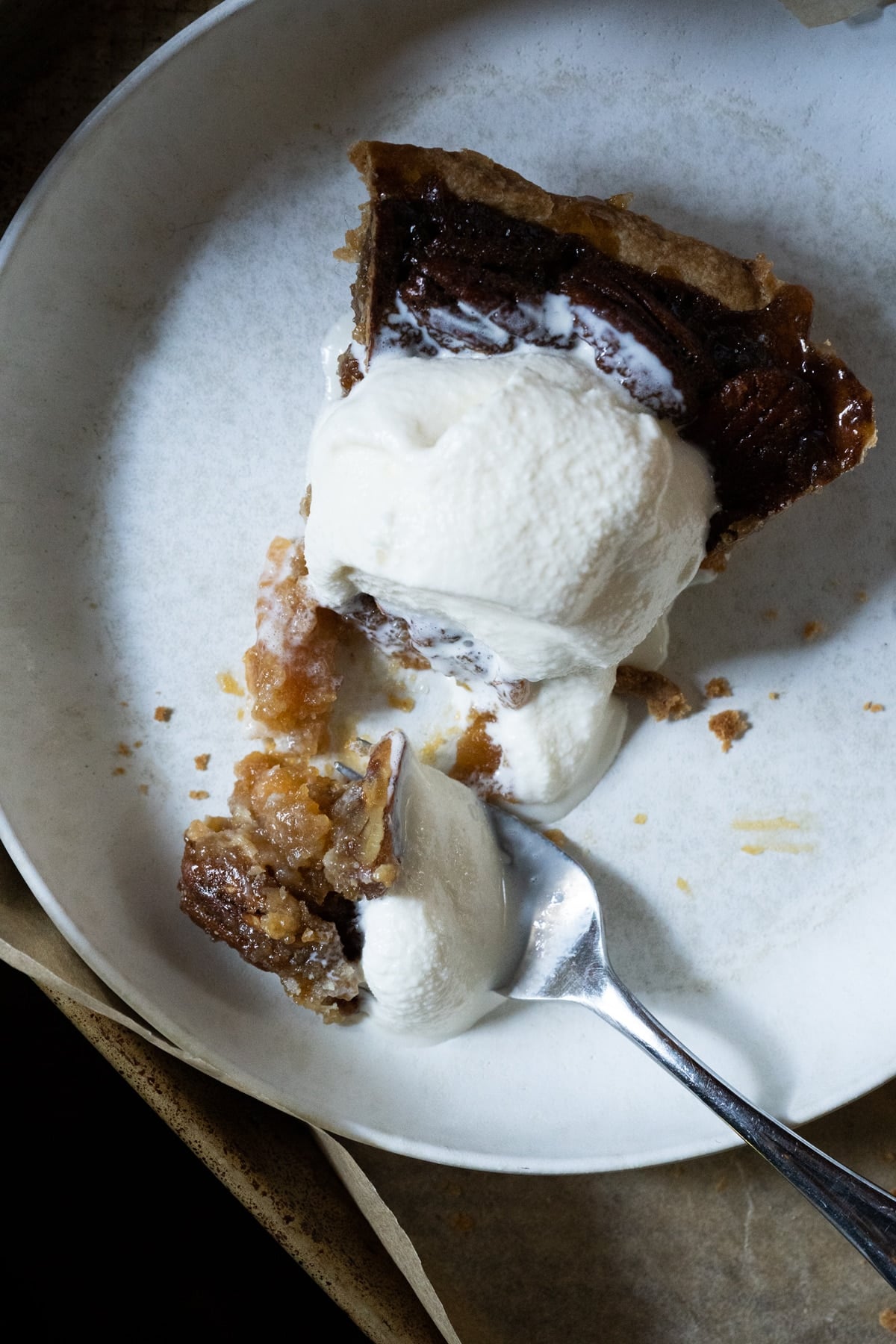 A slice of keto pecan pie with vanilla ice cream showing its gooey texture