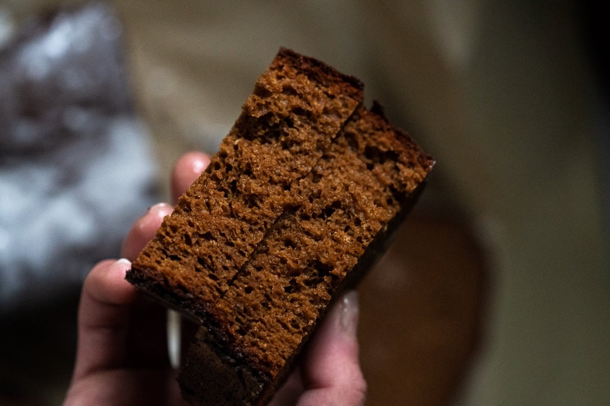 A closeup of a halved gingerbread slice showing the moist, fluffy and crumb like texture