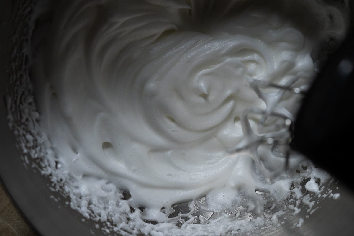 Closeup showing the fluffy texture of beating egg whites into soft peaks