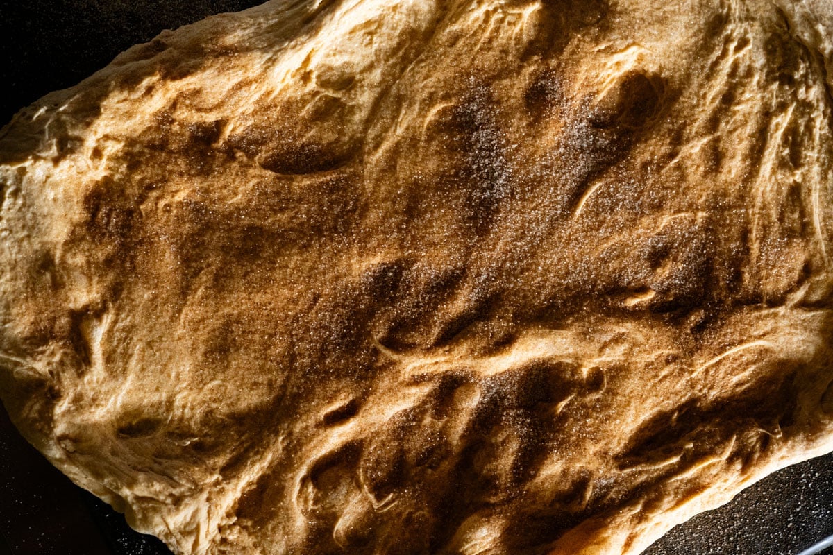 Laminating the pumpkin sourdough dough with a swirl of cinnamon sugar