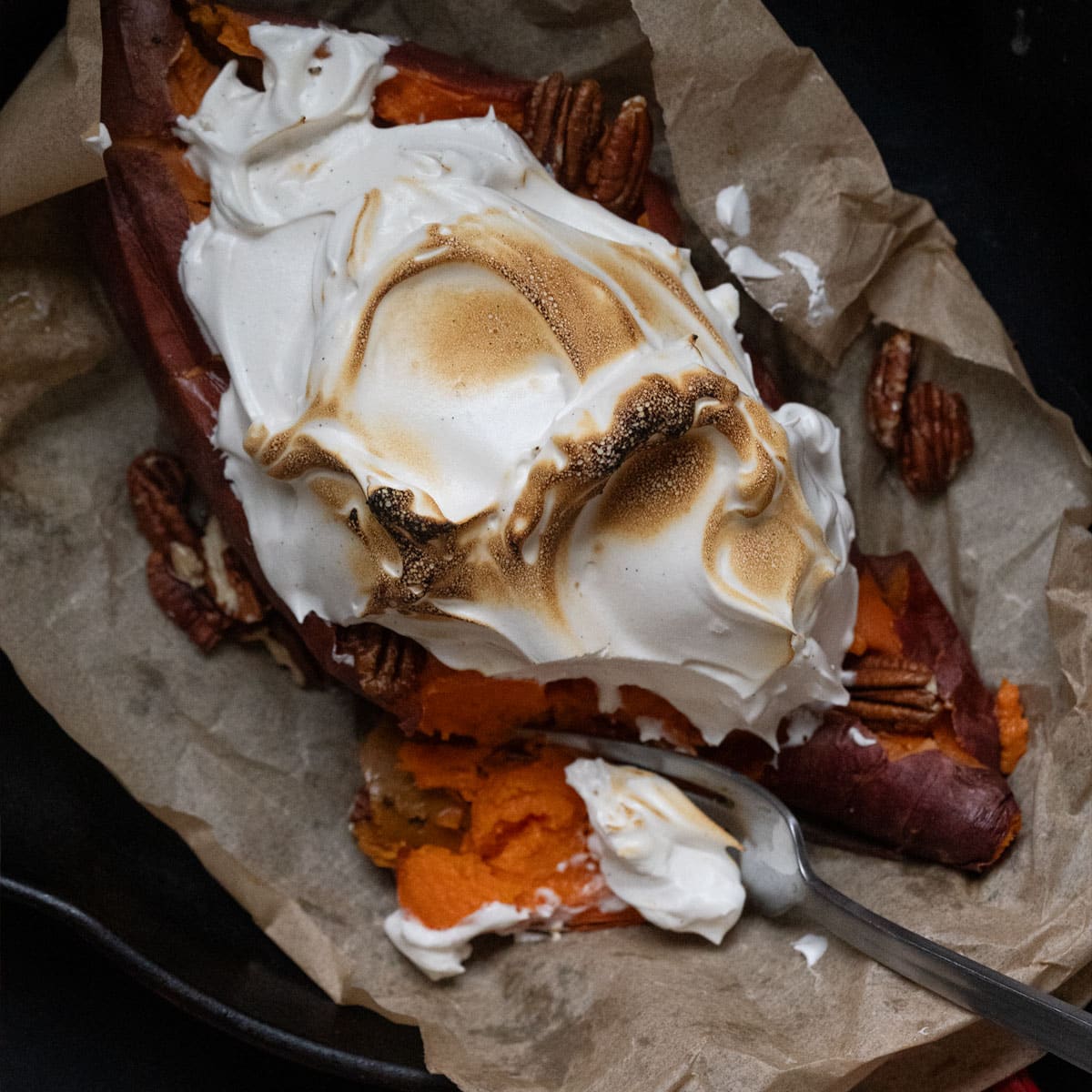 Homemade honey marshmallow fluff topping a baked sweet potato