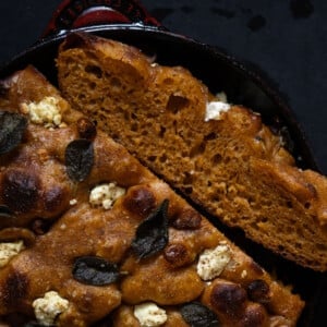 Pumpkin sourdough focaccia with caramelized maple garlic, goat cheese and sage baked in a red cast iron skillet
