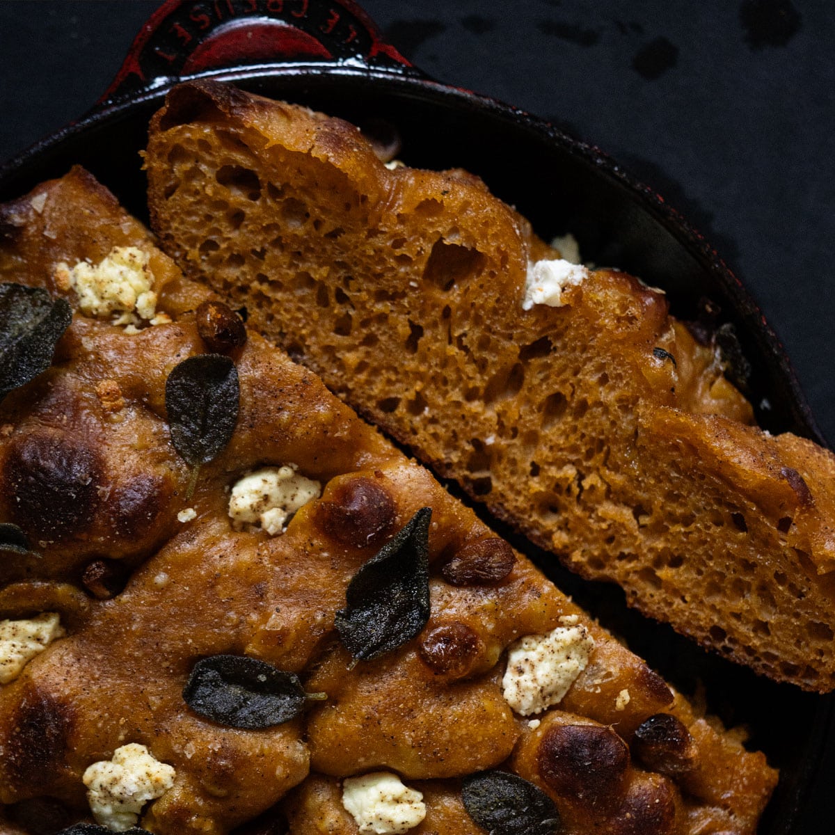 Pumpkin sourdough focaccia with caramelized maple garlic, goat cheese and sage baked in a red cast iron skillet