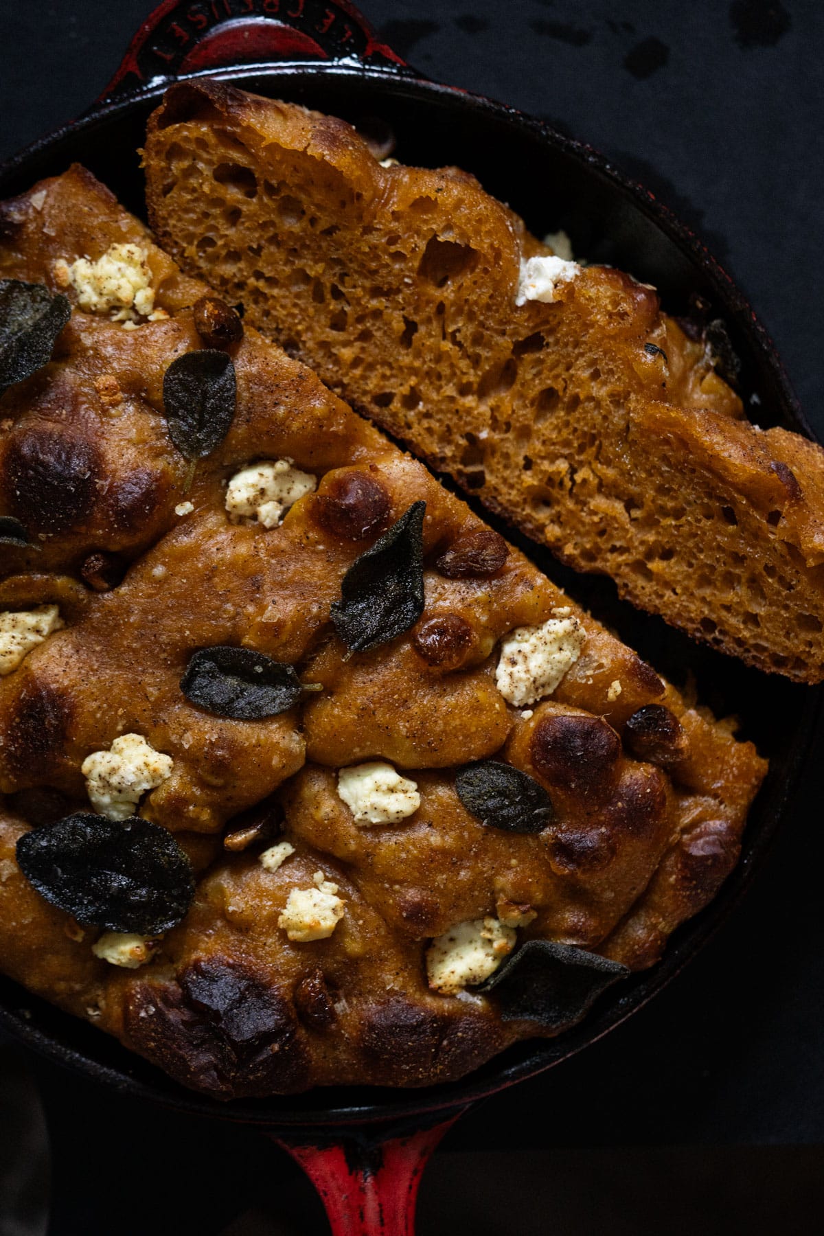 Pumpkin sourdough focaccia with caramelized maple garlic, goat cheese and sage baked in a red cast iron skillet