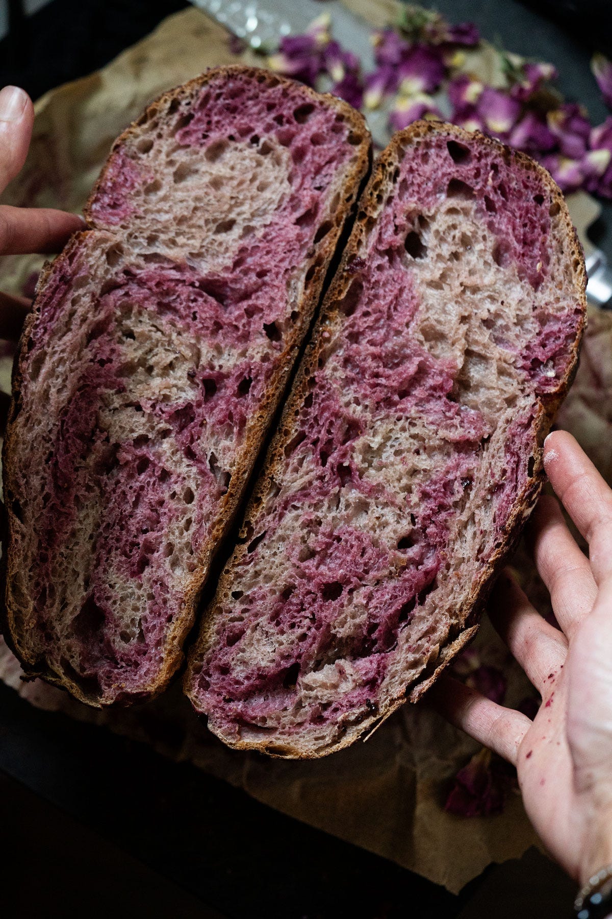A rose sugar strawberry sourdough halved showing a marbled pink crumb