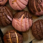 Closeup Mexican sourdough conchas with strawberry and chocolate seashell coatings