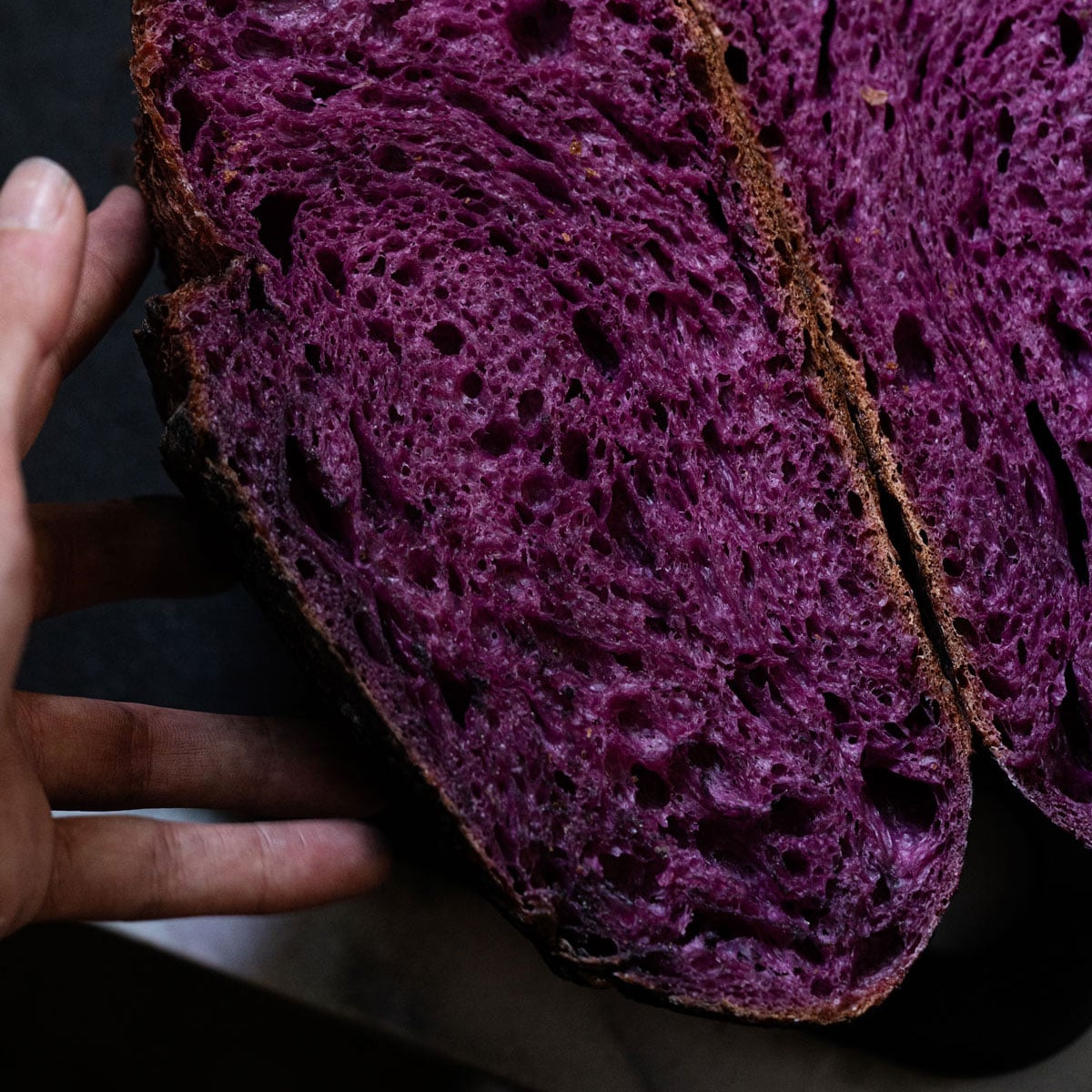 Purple sweet potato sourdough halved showing the bright colored crumb