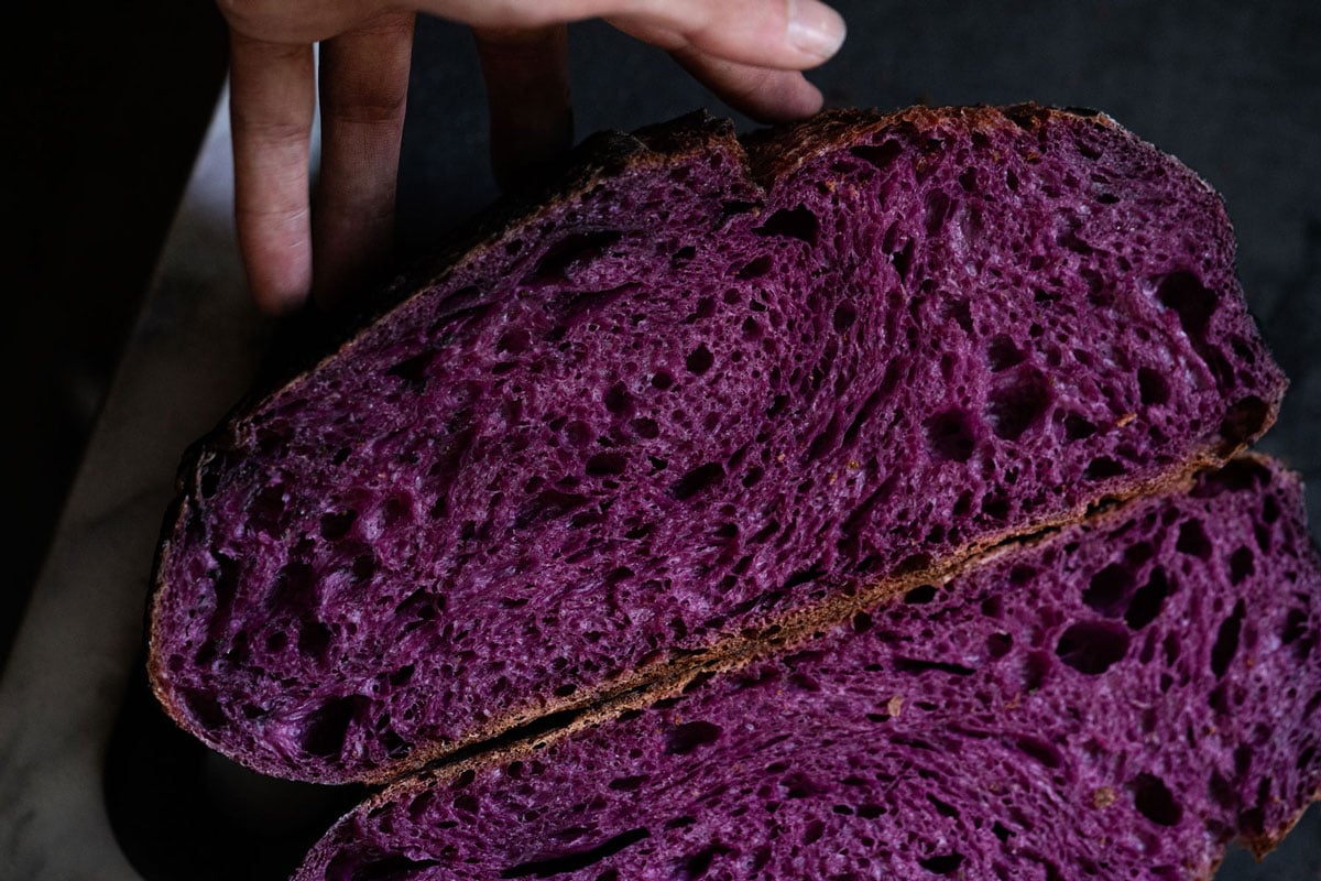 Purple sweet potato sourdough halved showing the bright colored crumb