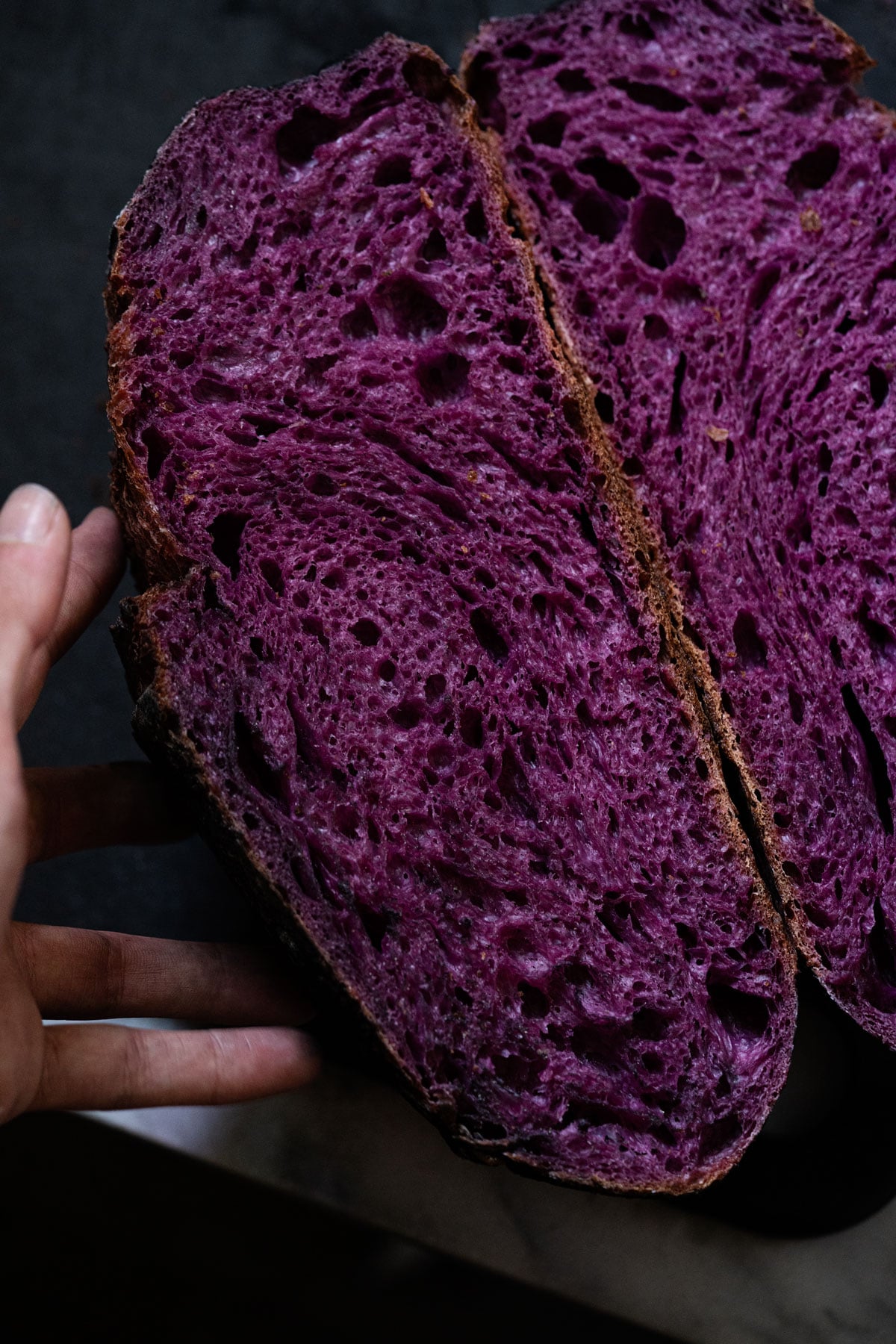 Purple sweet potato sourdough halved showing the bright colored crumb